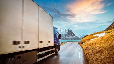 Truck on road in Norwegian fjord on sunset. Lofoten islands, Norway. Motion blur
